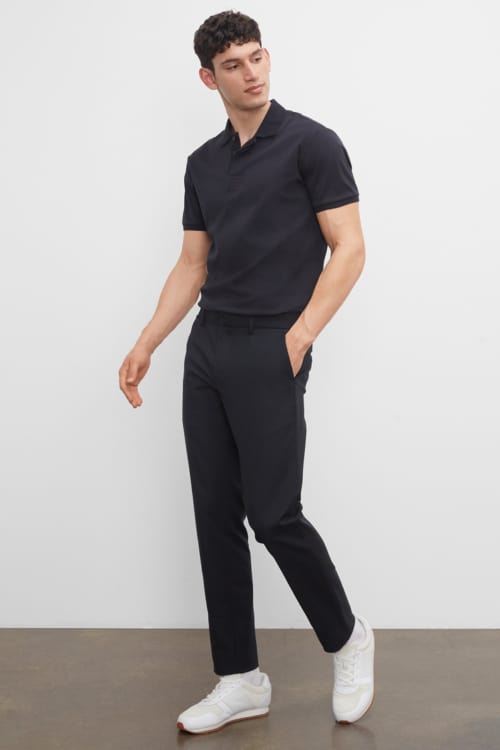 Men's minimalist navy trousers, polo shirt and white sneakers outfit