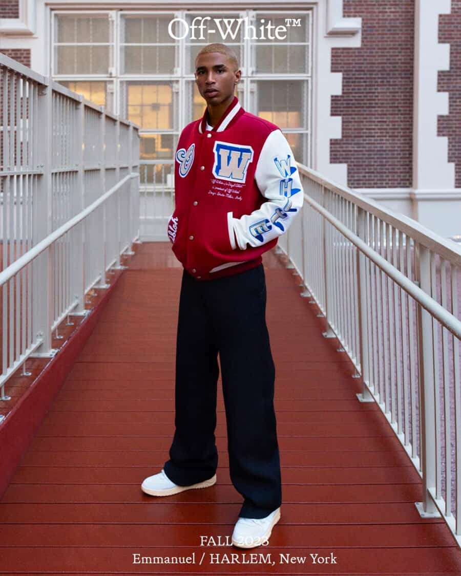 Men's Off-White streetwear Fall campaign with man wearing black loose pants, chunky white sneakers and branded red varsity jacket