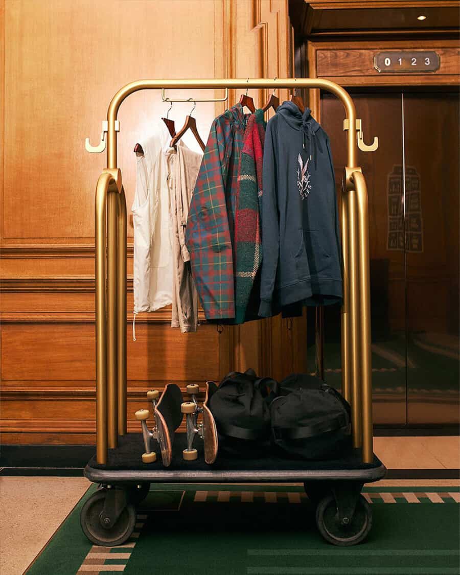 Selection of men's Pop Trading Company streetwear and skateboards on a hotel luggage trolley