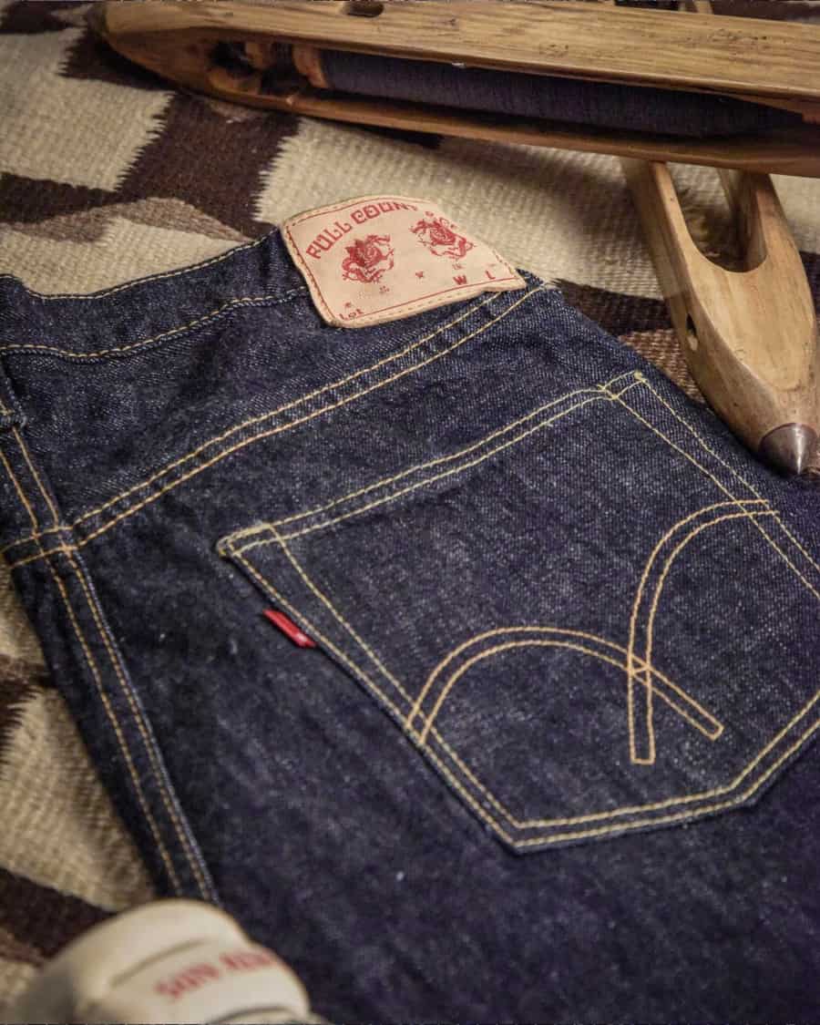 Pair of raw denim jeans laid out