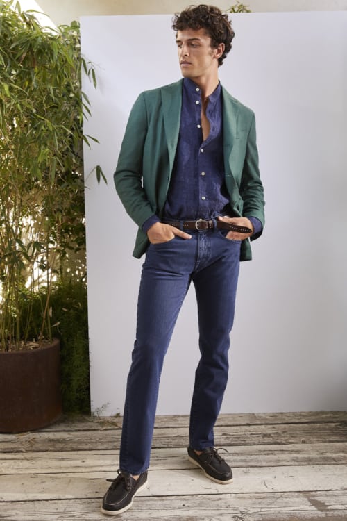 Men's dark jeans, navy Oxford shirt, green blazer and boat shoes outfit