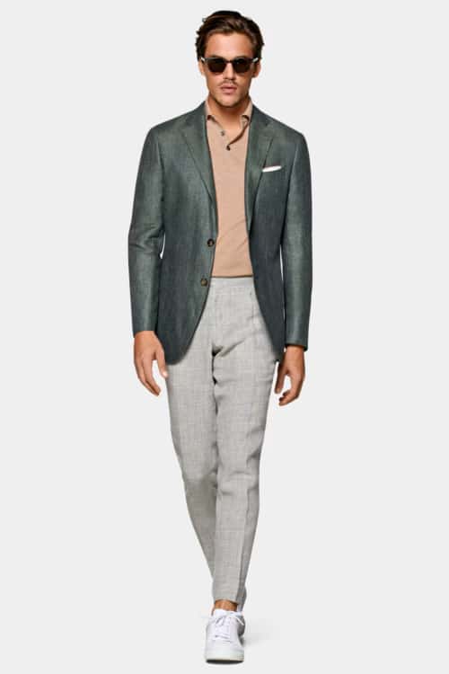 Men's grey trousers, green blazer, knitted polo shirt and white sneakers outfit