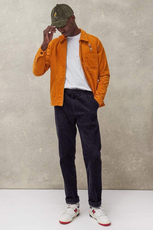 Men's 70s-inspired corduroy jacket and torusers with T-shirt and baseball cap outfit