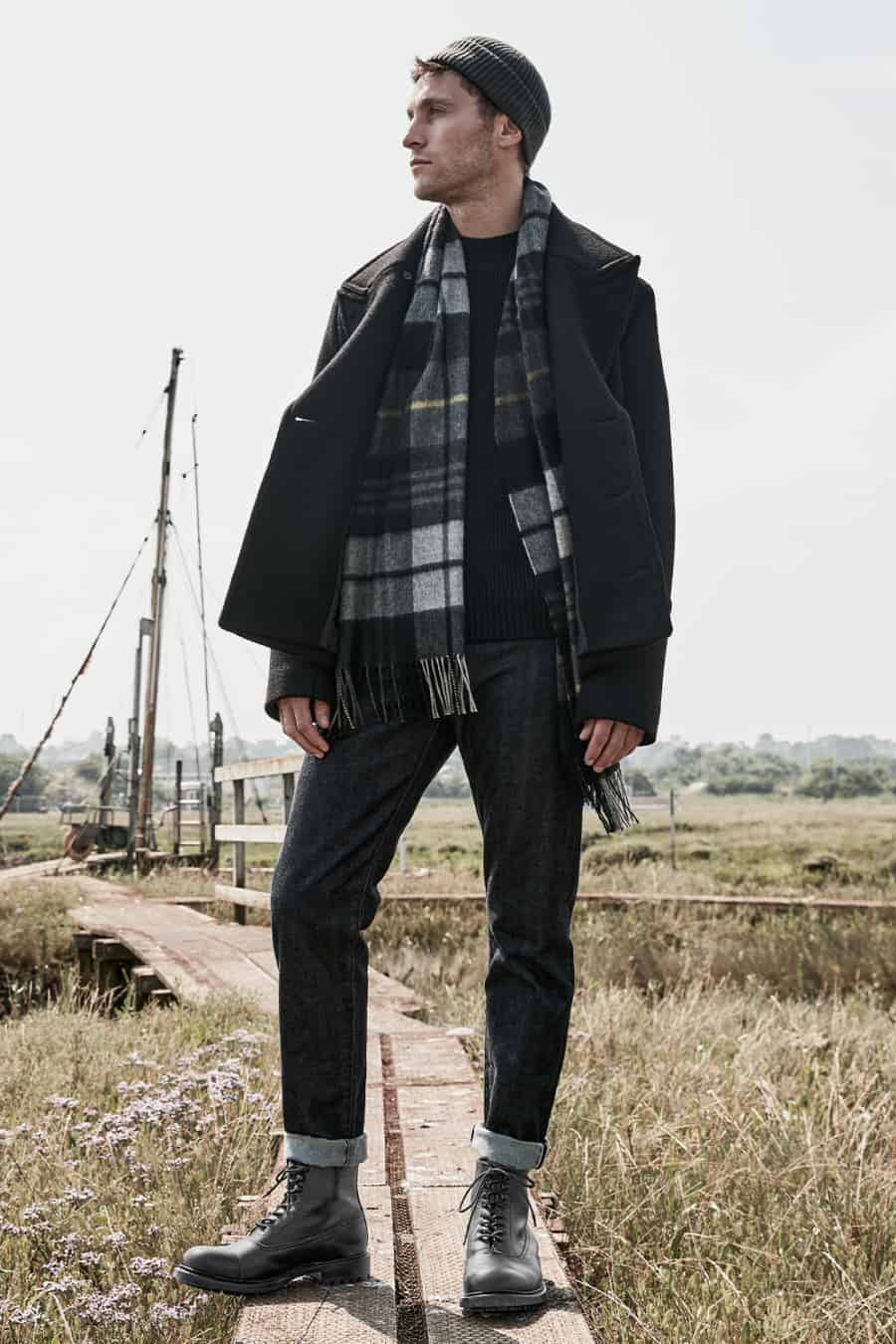 Men's selvedge jeans, black boots, ribbed sweater and black peacoat outfit