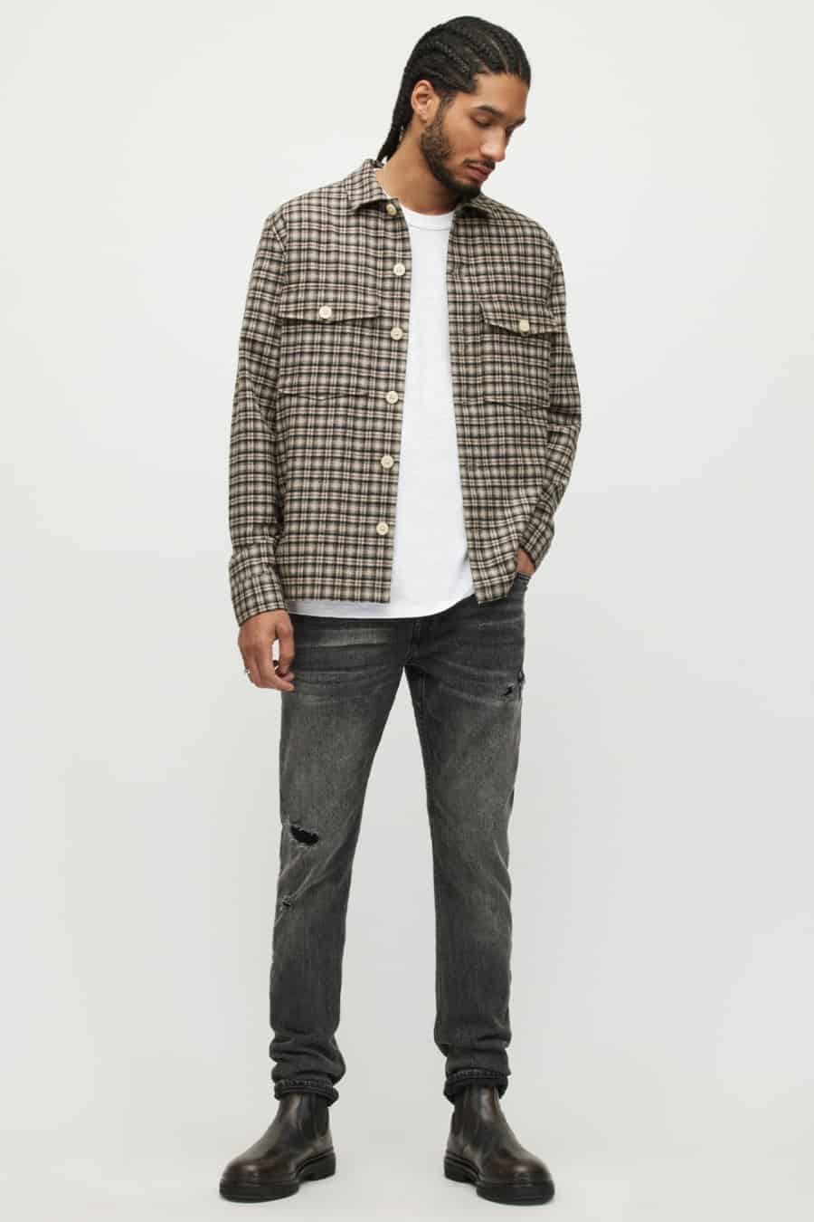 Men's white tee and checked overshirt worn with jeans and boots