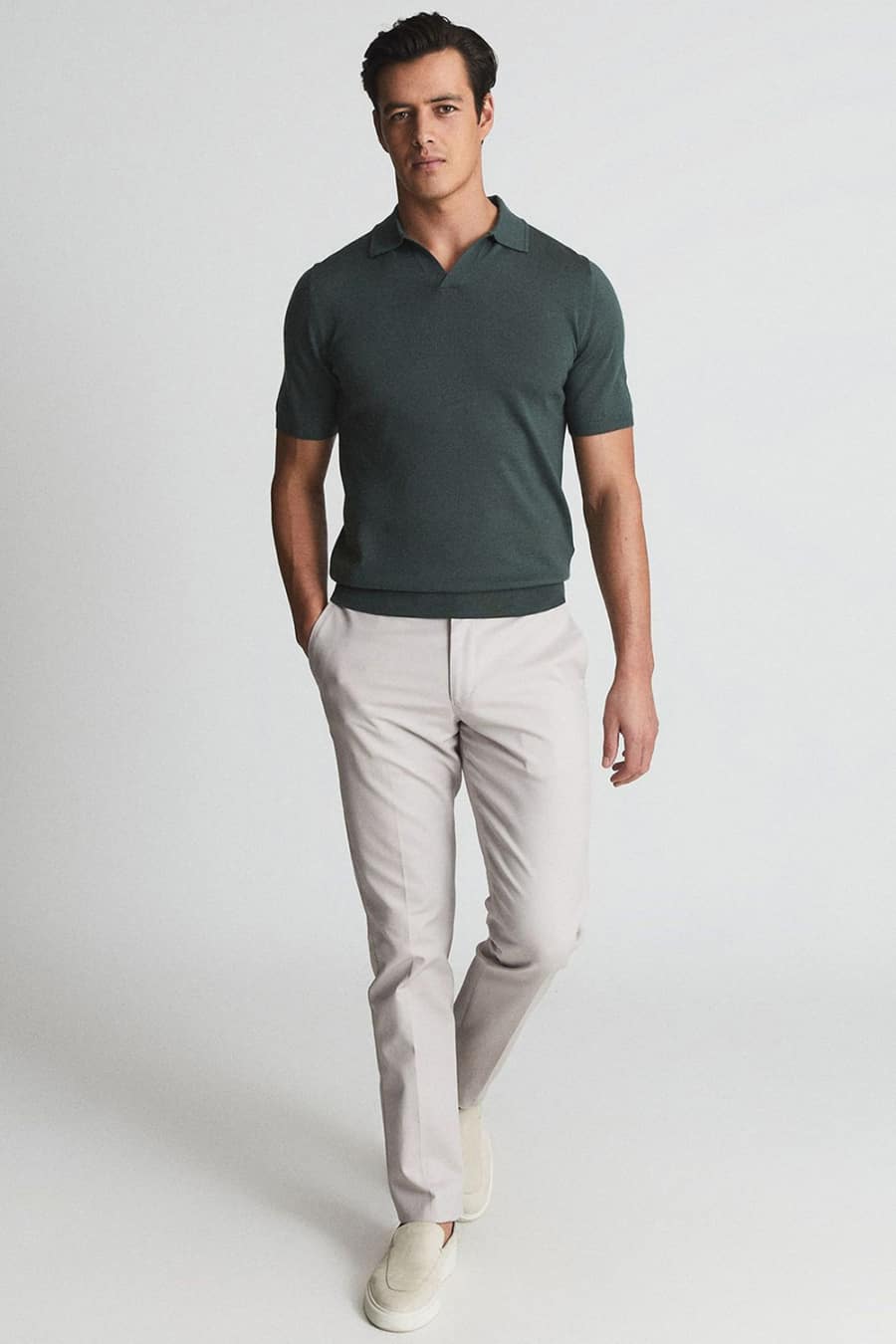 Men's light grey pants, green polo shirt and slip-on sneakers outfit