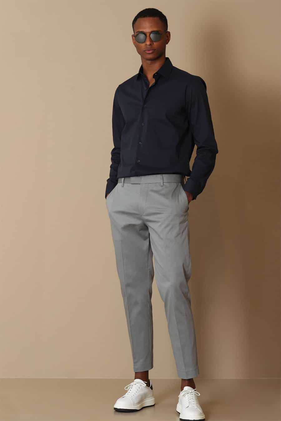 Men's gcropped grey pants, navy dress shirt and white sneakers outfit