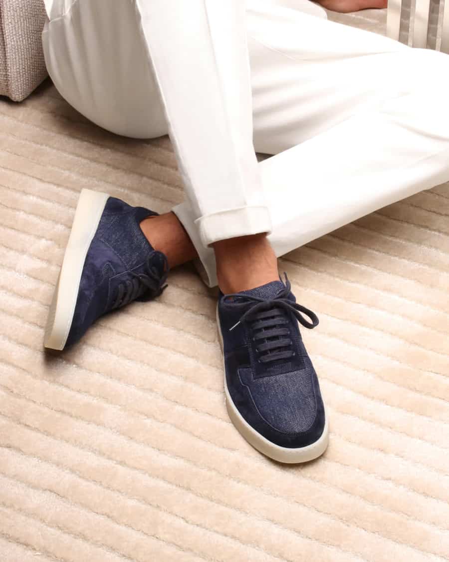 Men's minimal blue fabric sneakers worn with cuffed white pants