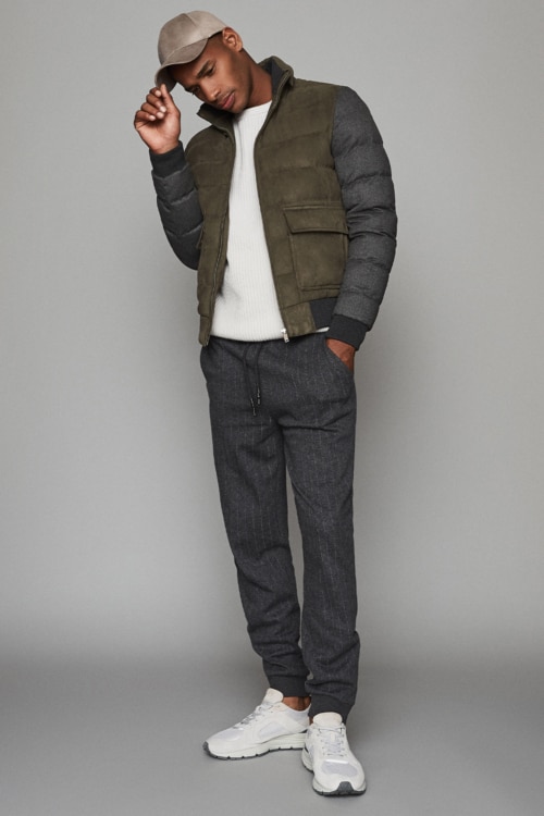 Men's tailored sweatpants, white T-shirt, quilted jacket and baseball cap athleisure outfit