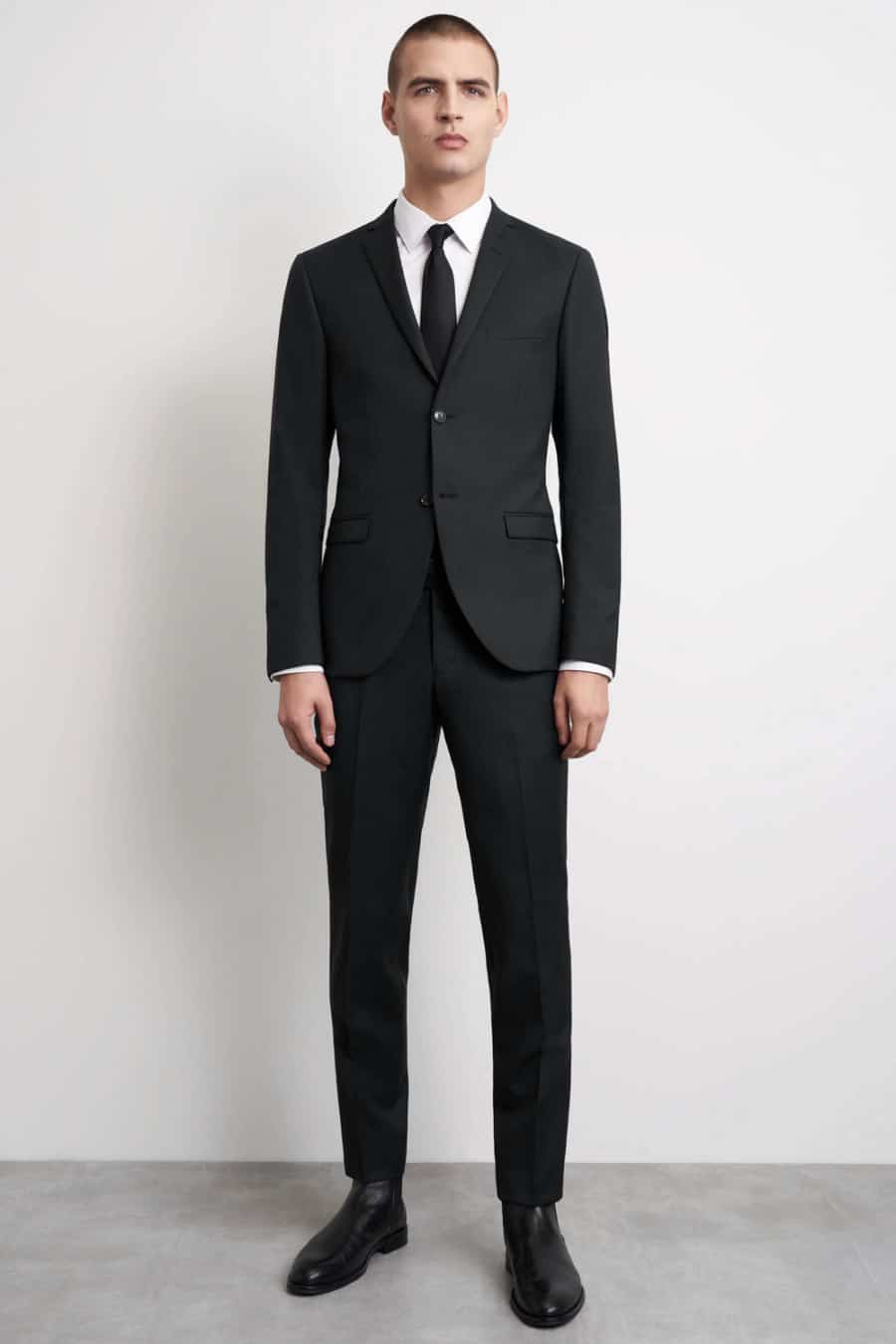 Men's black suit, white shirt, black tie and black leather Chelsea boots outfit