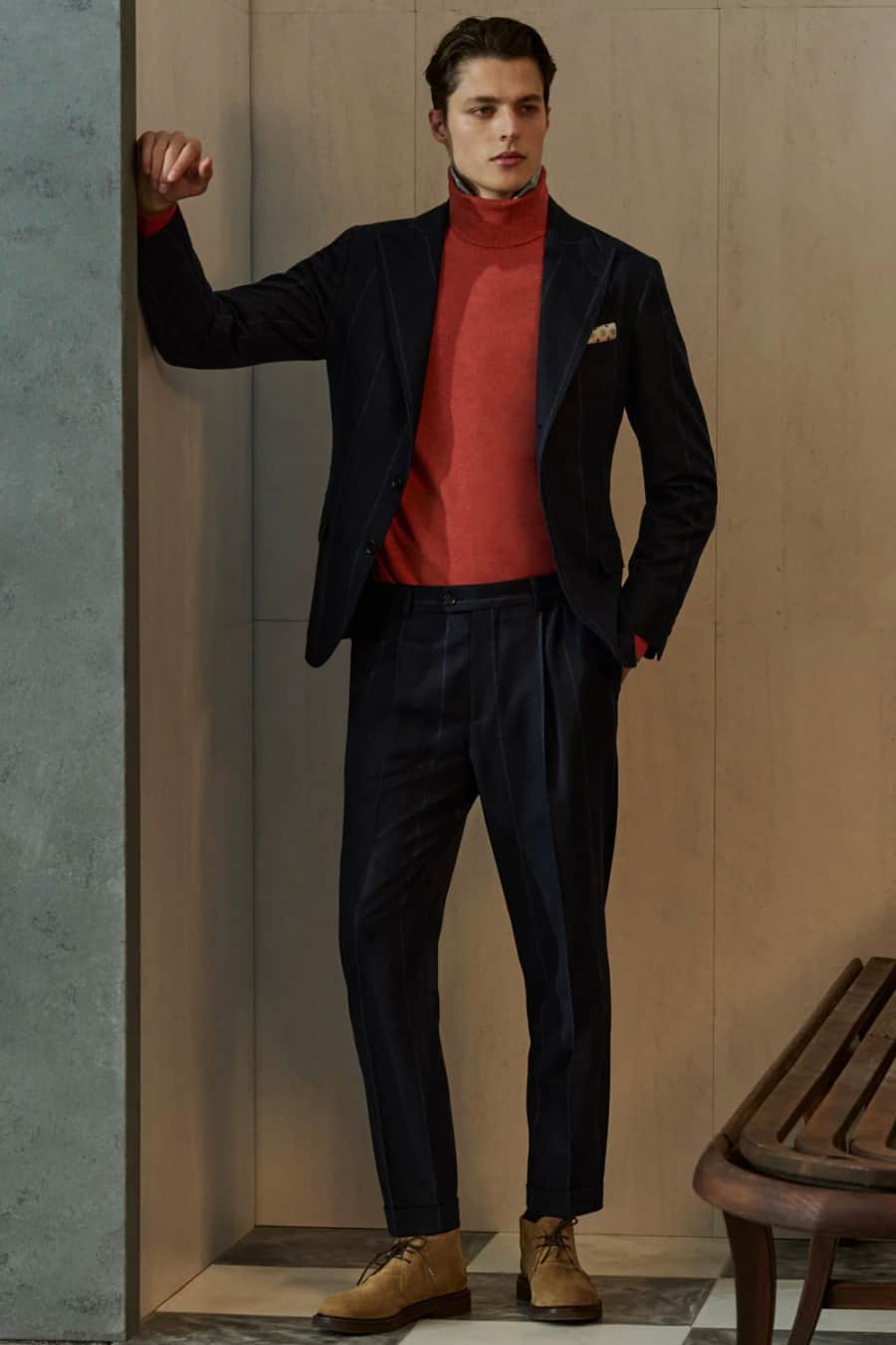 Men's dark navy suit with red turtleneck and suede chukka boots outfit
