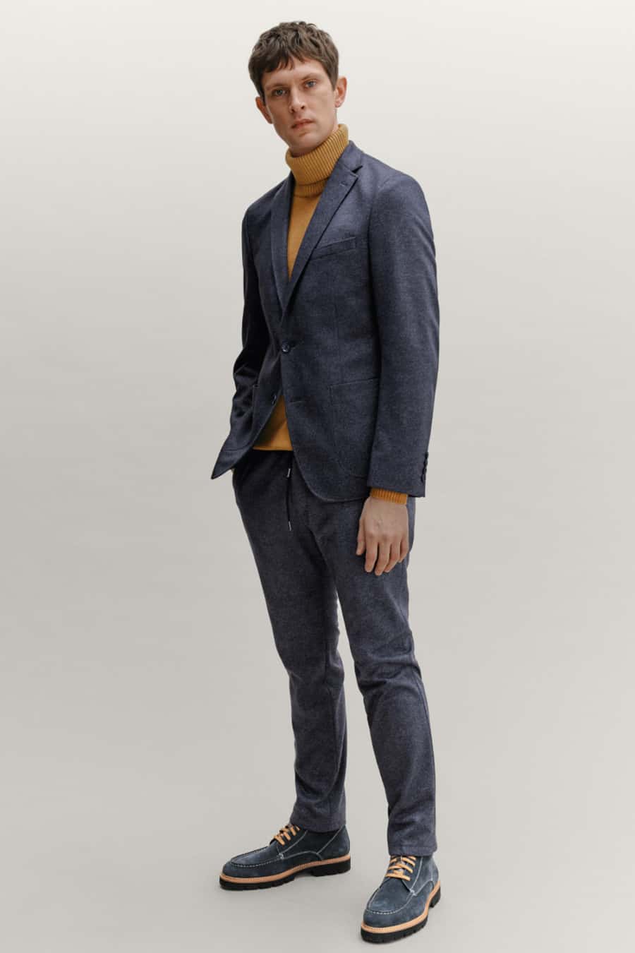 Men's textured suit, yellow chunky roll neck and blue suede work boots outfit