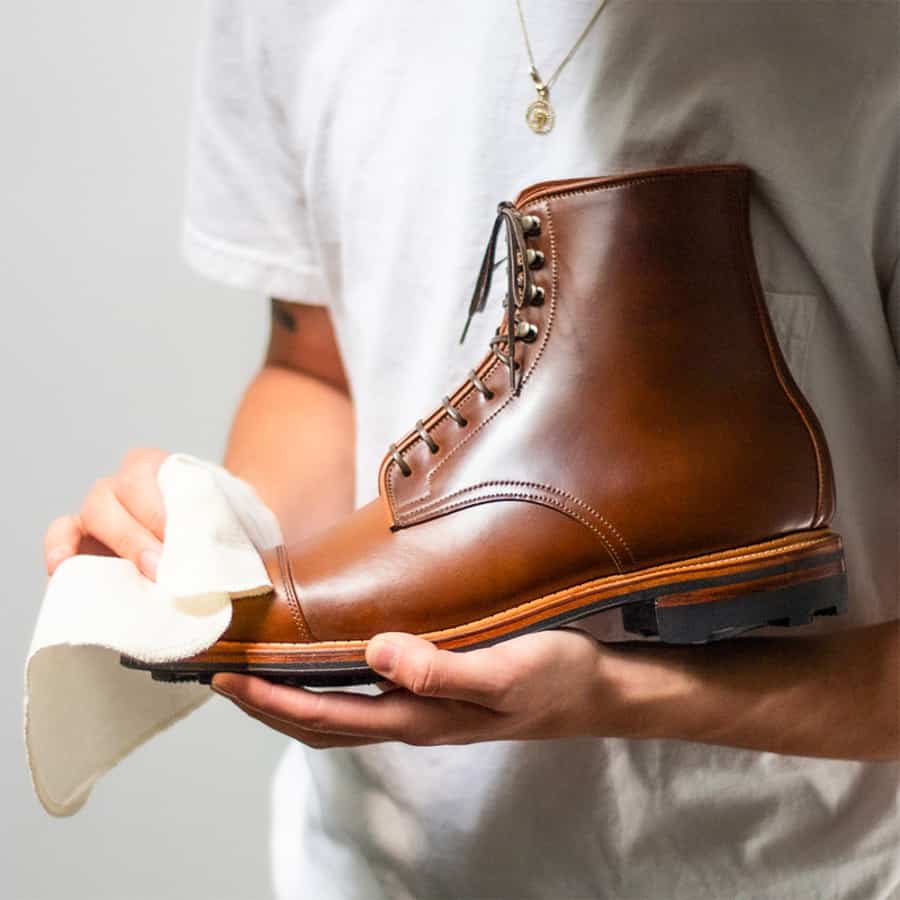 A pair of expensive brown leather work boots for men being polished
