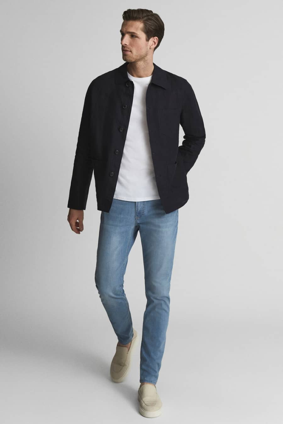 Men's light wash jeans, white T-shirt and navy lightweight jacket with suede loafers outfit