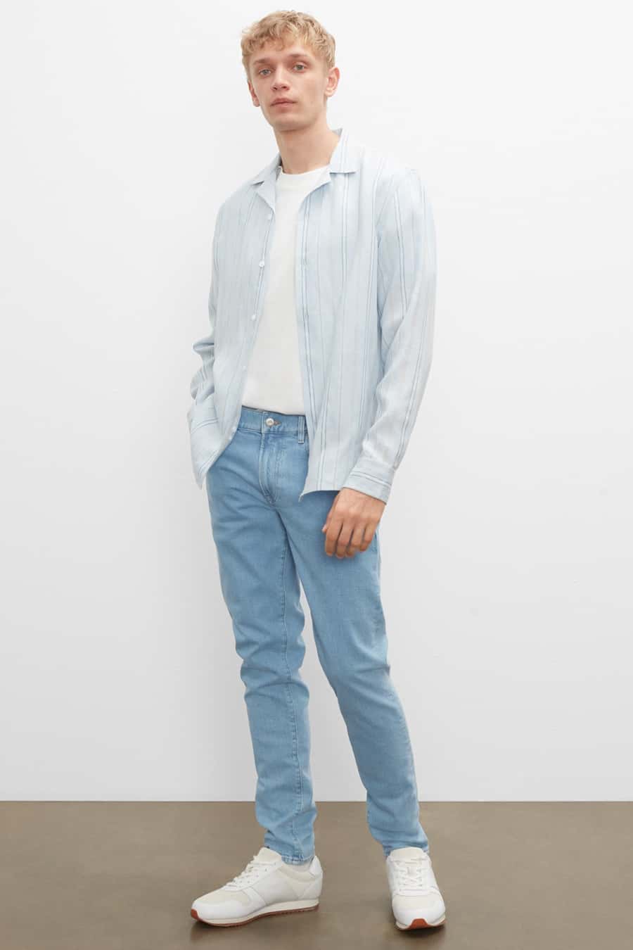 Men's light blue jeans, white T-shirt, sky blue vertical striped shirt and white sneakers outfit