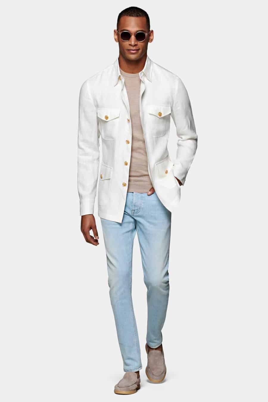 Men's light wash jeans, beige T-shirt, white safari jacket and suede loafers outfit