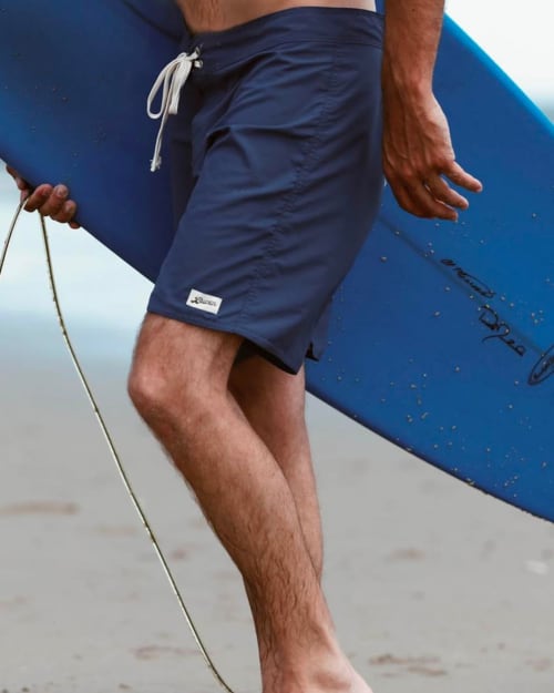 Close up of a man wearing navy Bather swim shorts