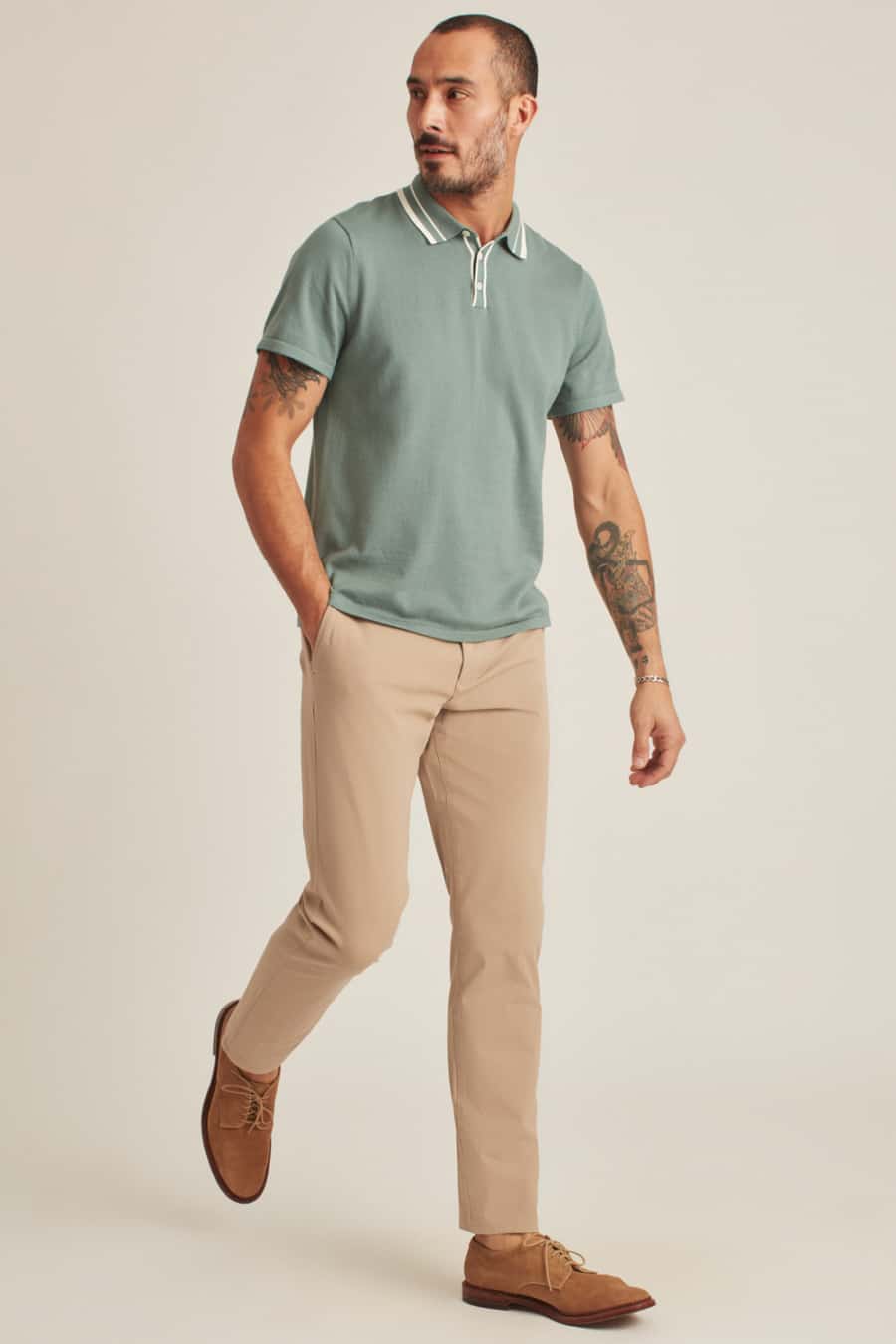 Men's khaki pants, green knitted polo shirt and suede Derby shoes outfit