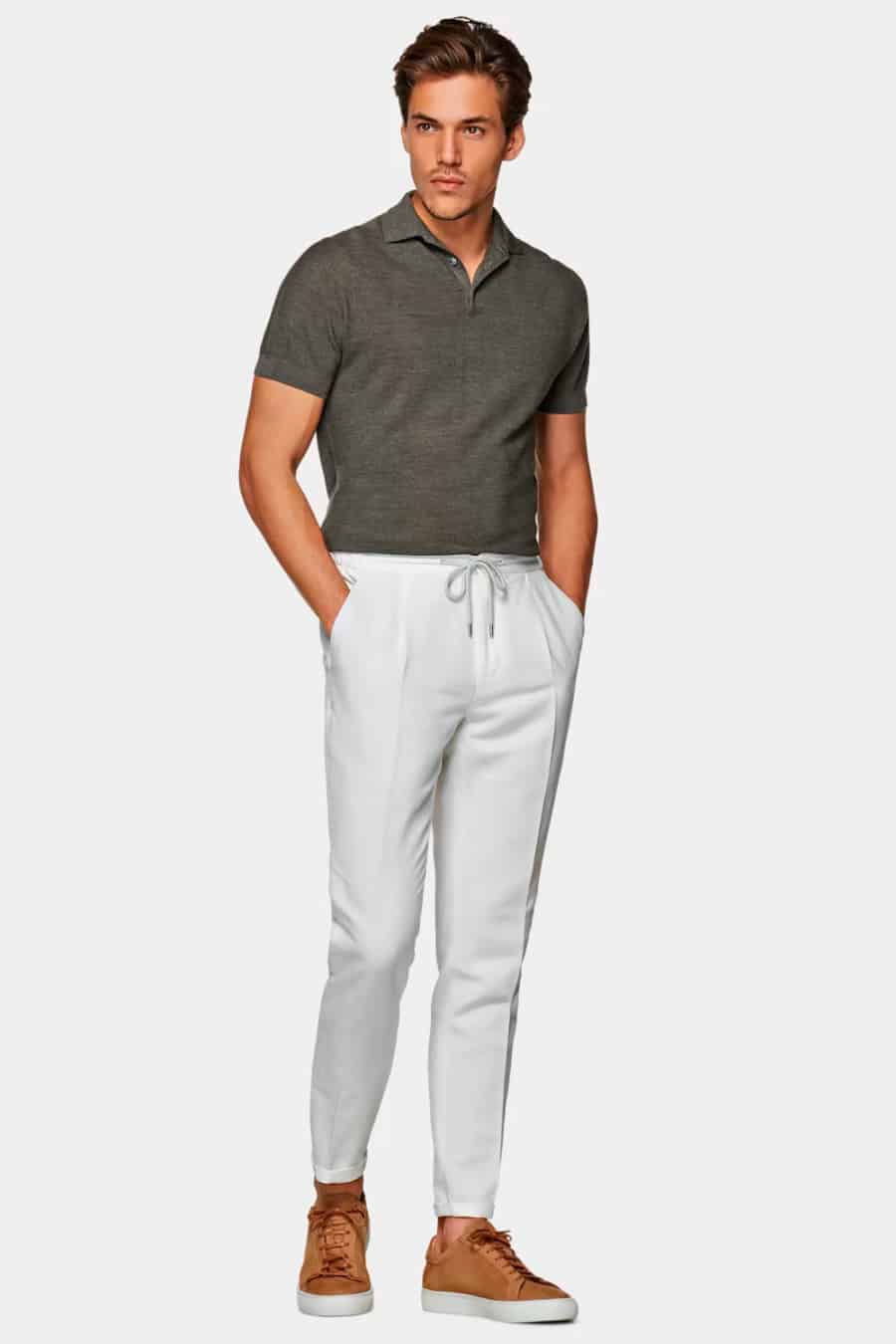Men's white drawstring pants, tucked in merino polo shirt and brown sneakers outfit