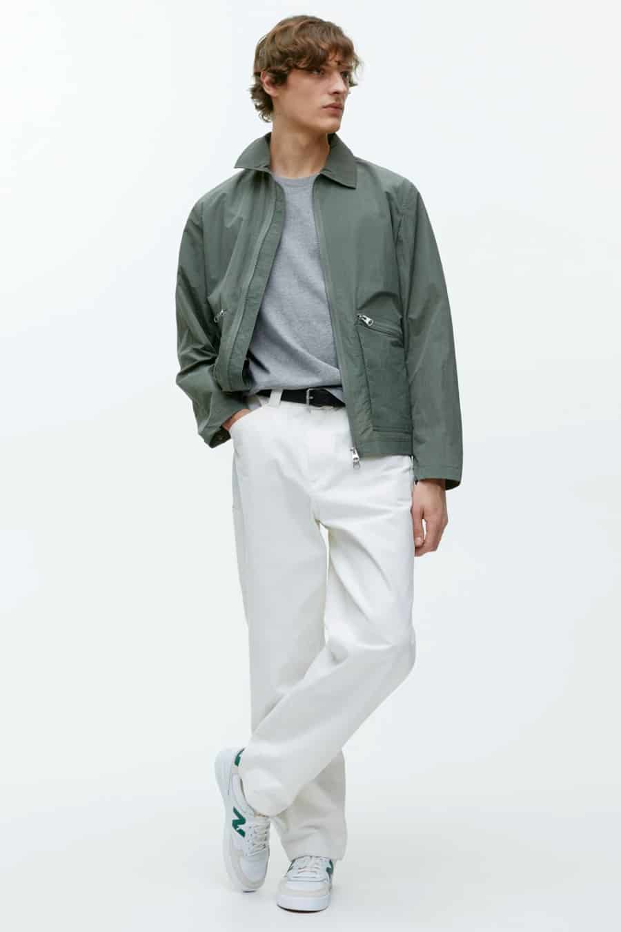 Men's white pants, grey T-shirt, green jacket and white sneakers outfit