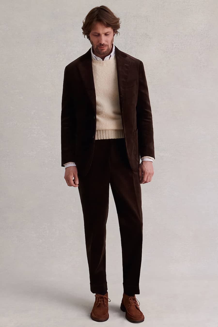 Men's brown corduroy suit, ecru sweater, suede brown chukka boots outfit