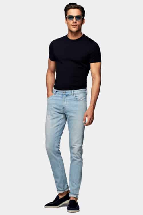 Men's light wash slim fit jeans, black tucked in T-shirt and suede loafers outfit