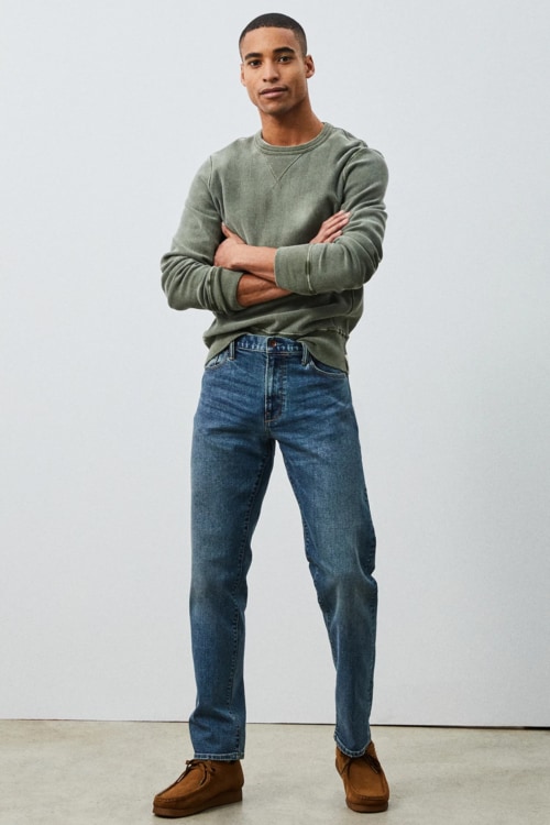 Men's straight cut jeans, green sweatshirt and suede boots outfit