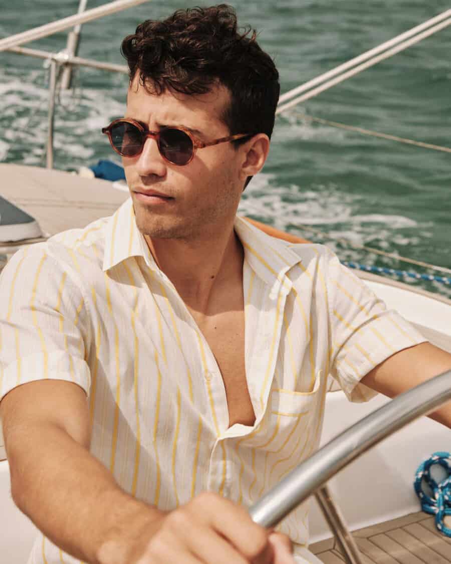 Man on boat wearing white stripe shirt and luxury tortoiseshell Johann Wolff sunglasses