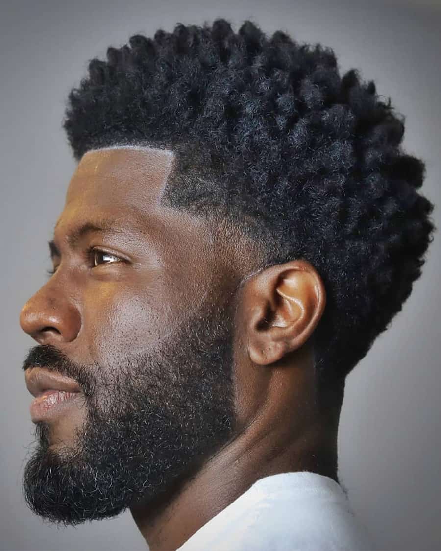 Black men's grown out, medium length shaped afro with low taper fade