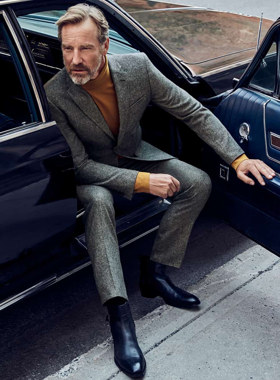 Men's grey flannel suit, mustard turtleneck and black leather Chelsea boots outfit