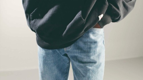 Luxury pair of light wash men's jeans worn with oversized black sweatshirt