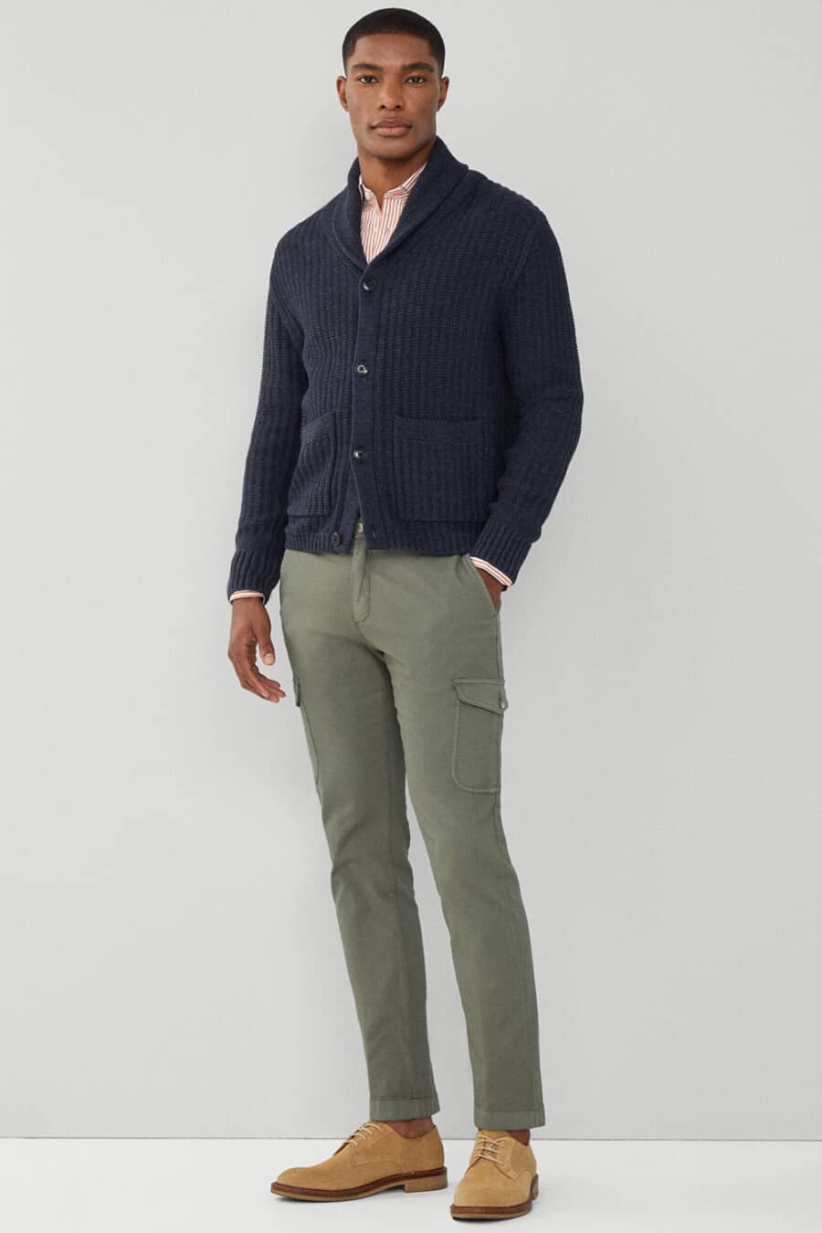 Men's green cargo pants, red/white stripe shirt, navy shawl collar cardigan and tan orange suede shoes worn sockless smart-casual outfit