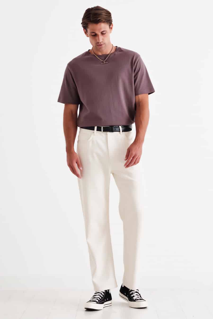 Men's relaxed fit white pants, tucked in T-shirt, black belt and black Converse high-tops outfit