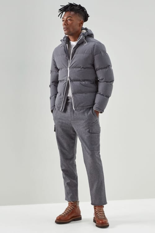 Men's grey combat pants, white T-shirt, grey padded down jacket and brown leather hiking boots outfit