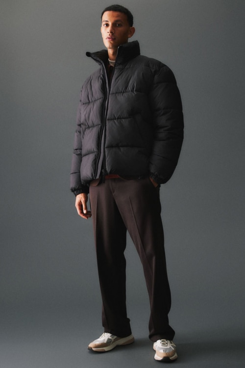 Men's brown relaxed pants, black loose puffer jacket and running shoes outfit