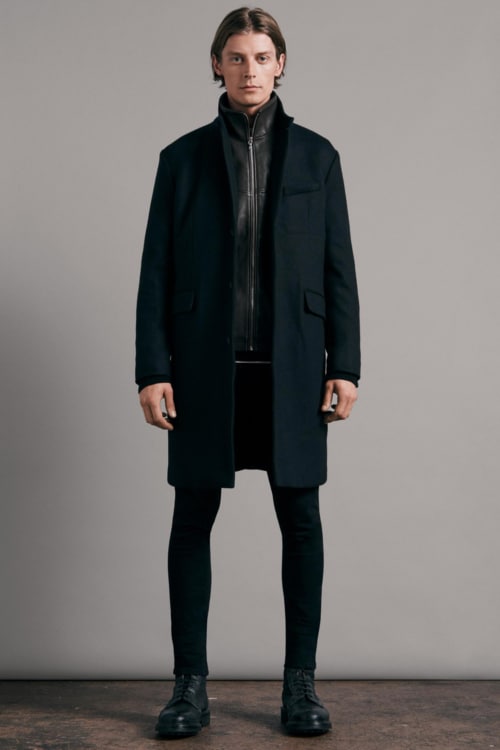 Men's black jeans, black zip up track jacket, black overcoat and black leather boots outfit