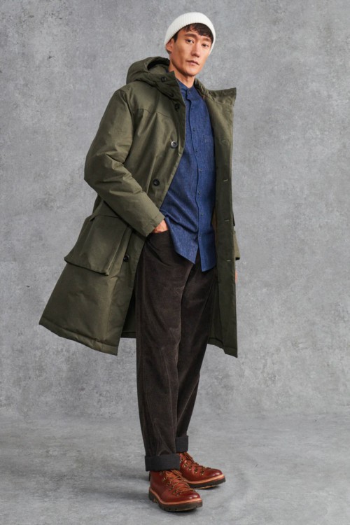 Men's loose corduroy trousers, blue denim shirt, green parka jacket and brown leather hiking boots outfit