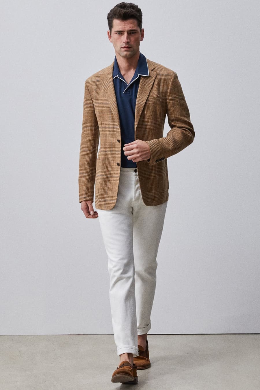 Men's white jeans, brown checked blazer, navy open collar polo shirt and loafers outfit