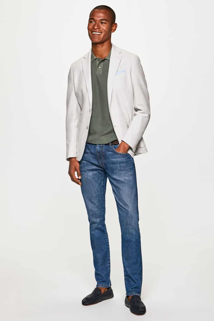 Men's light wash jeans, white blazer, green polo shirt and driving shoes outfit