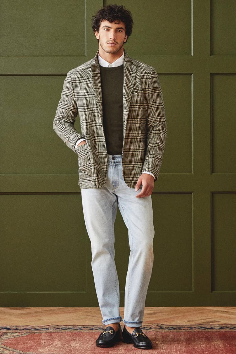 Men's light wash jeans, white shirt, sweater, Prince of Wales checked blazer and black loafers outfit
