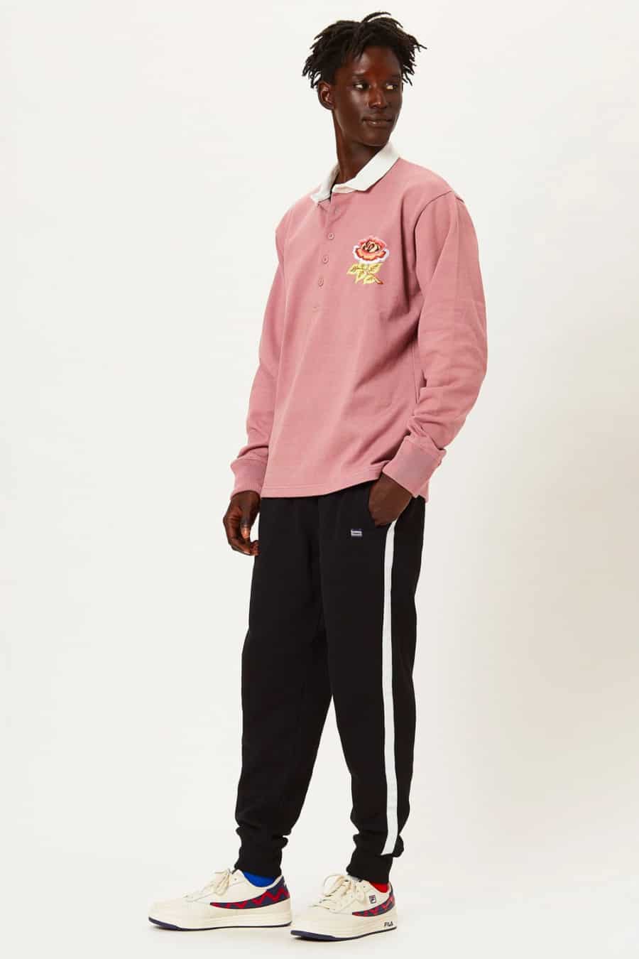 Men's stripe sweatpants, pink rugby shirt and white sneakers outfit