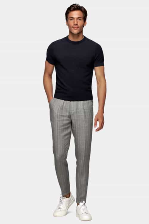 Men's black T-shirt tucked into chalk stripe grey trousers with white sneakers outfit