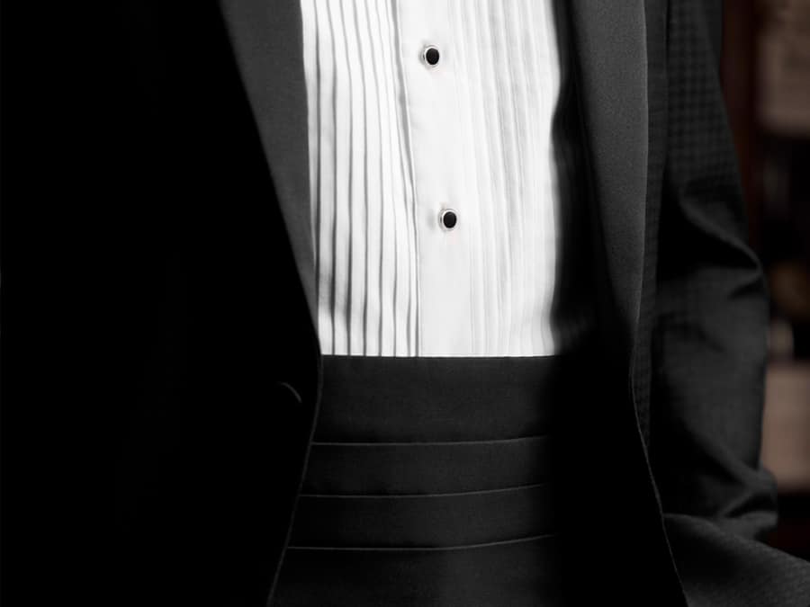 Black tie dinner jacket worn with a white bib dress shirt and black silk cummerbund