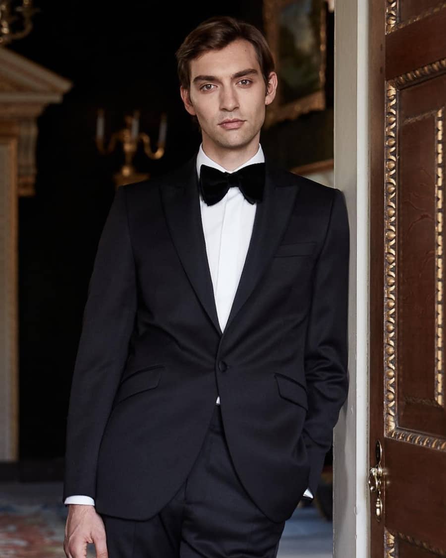 Man wearing traditional black tie dinner jacket, dress shirt and black bow tie