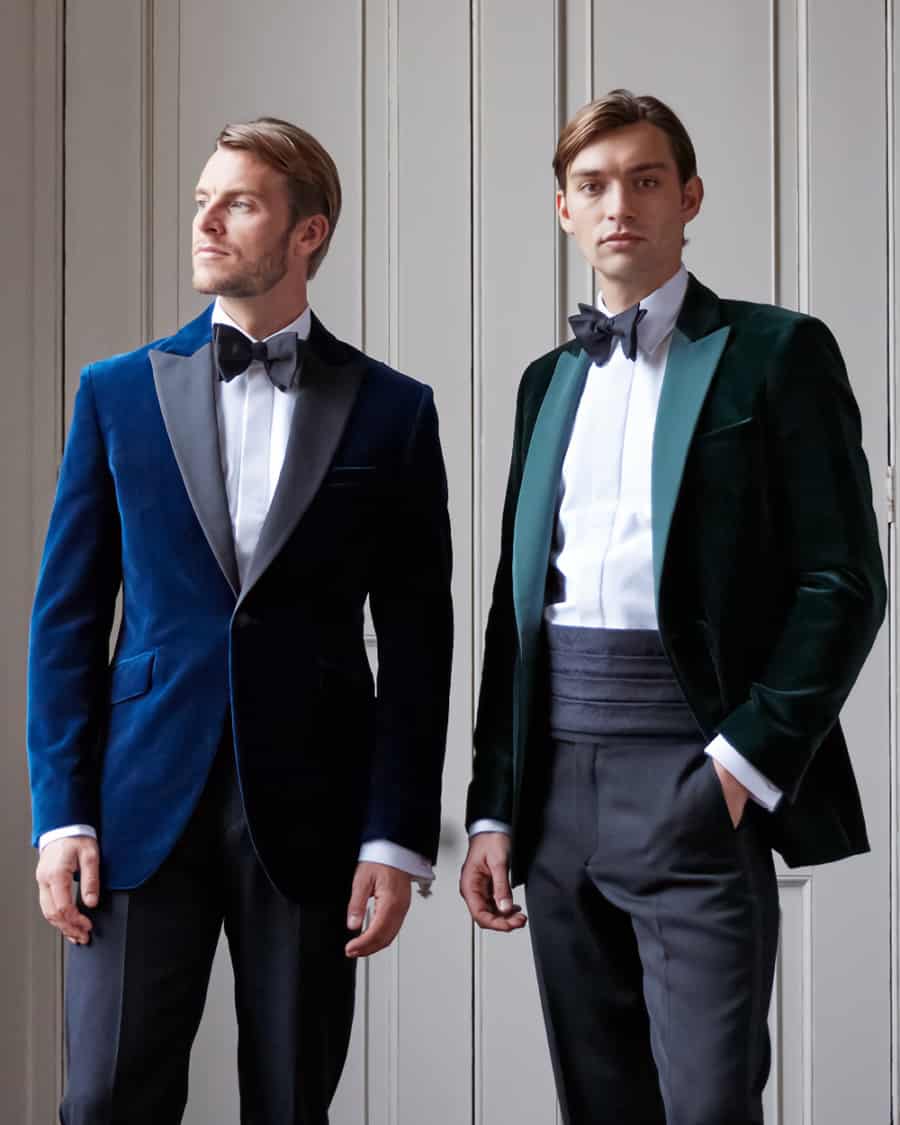 Two men wearing velvet dinner jackets dress trousers, white dress shirts and black bow ties for black tie event