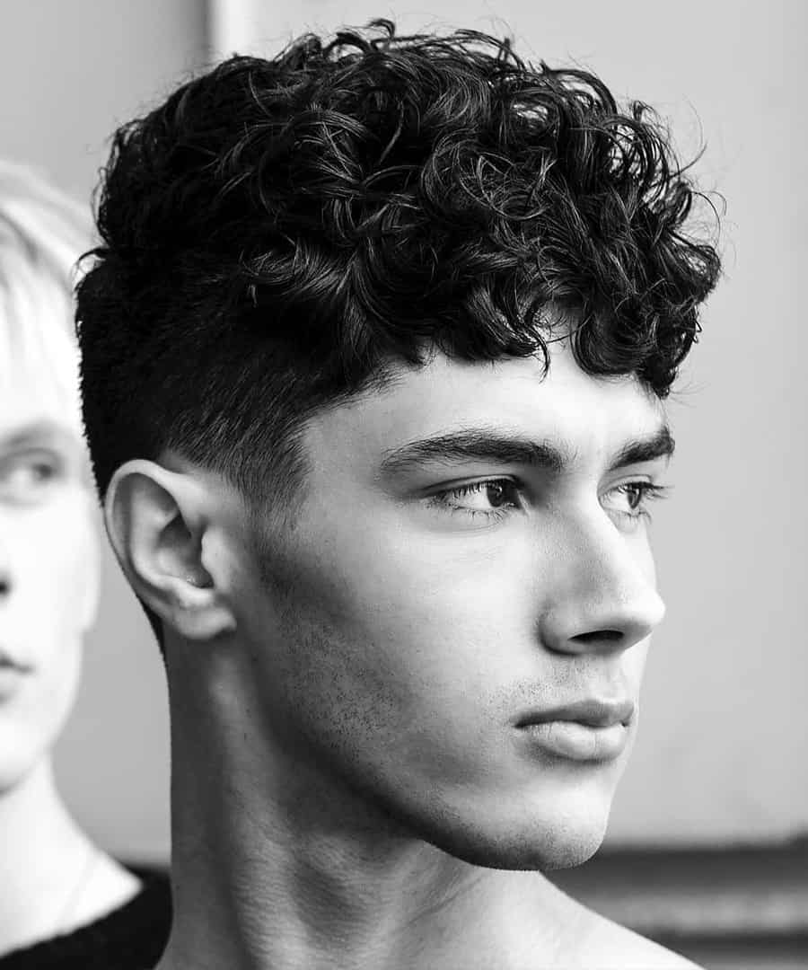 Neat curly hairstyle with clean taper fade