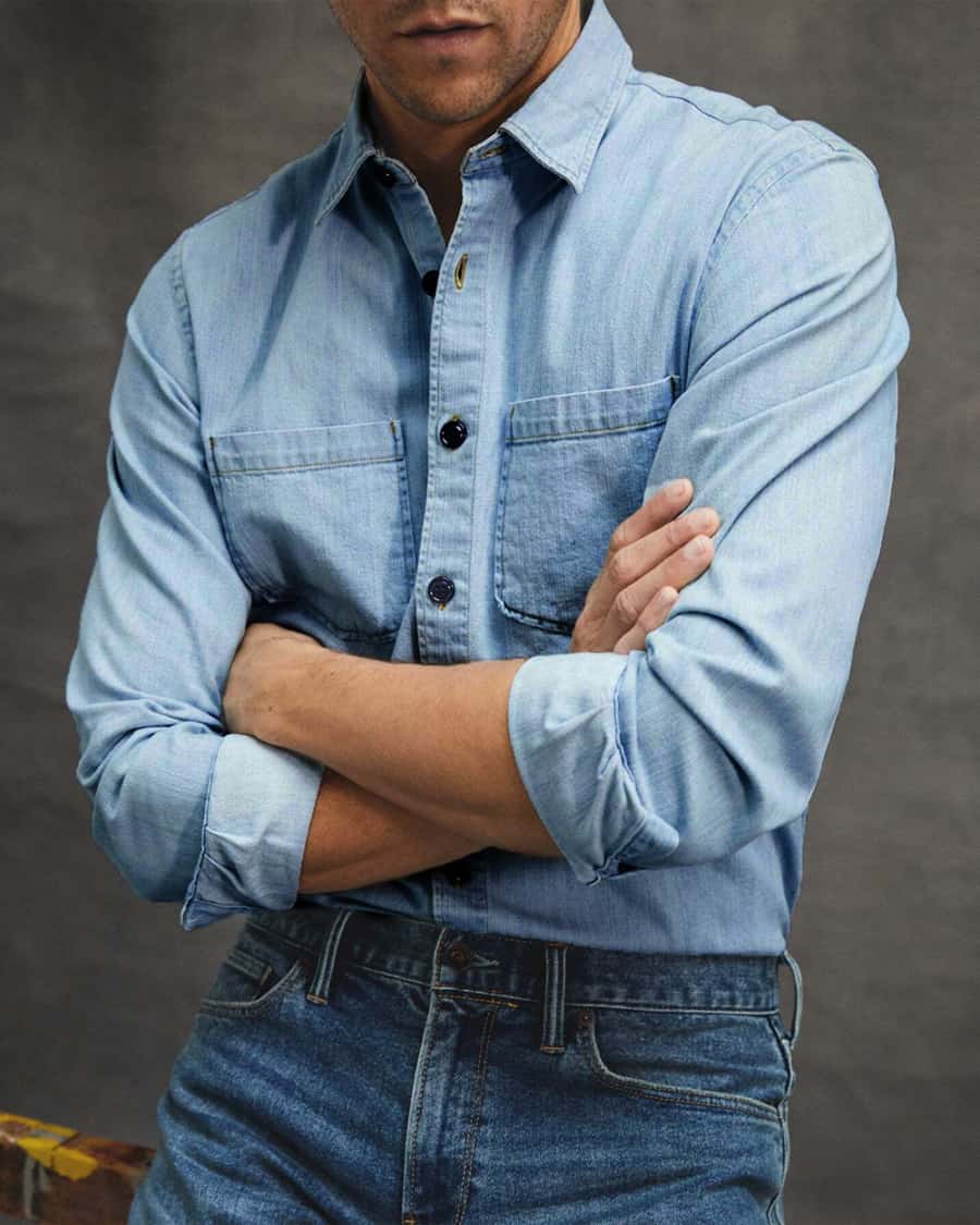 Men's bleached light wash denim shirt worn with mid-blue denim jeans