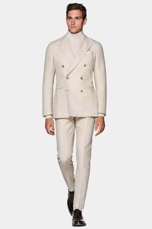 Men's off-white double-breasted suit worn with white roll neck sweater