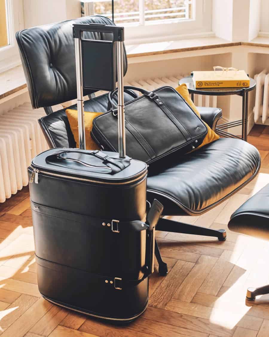 Vocier luxury luggage in front of and on an Eames chair