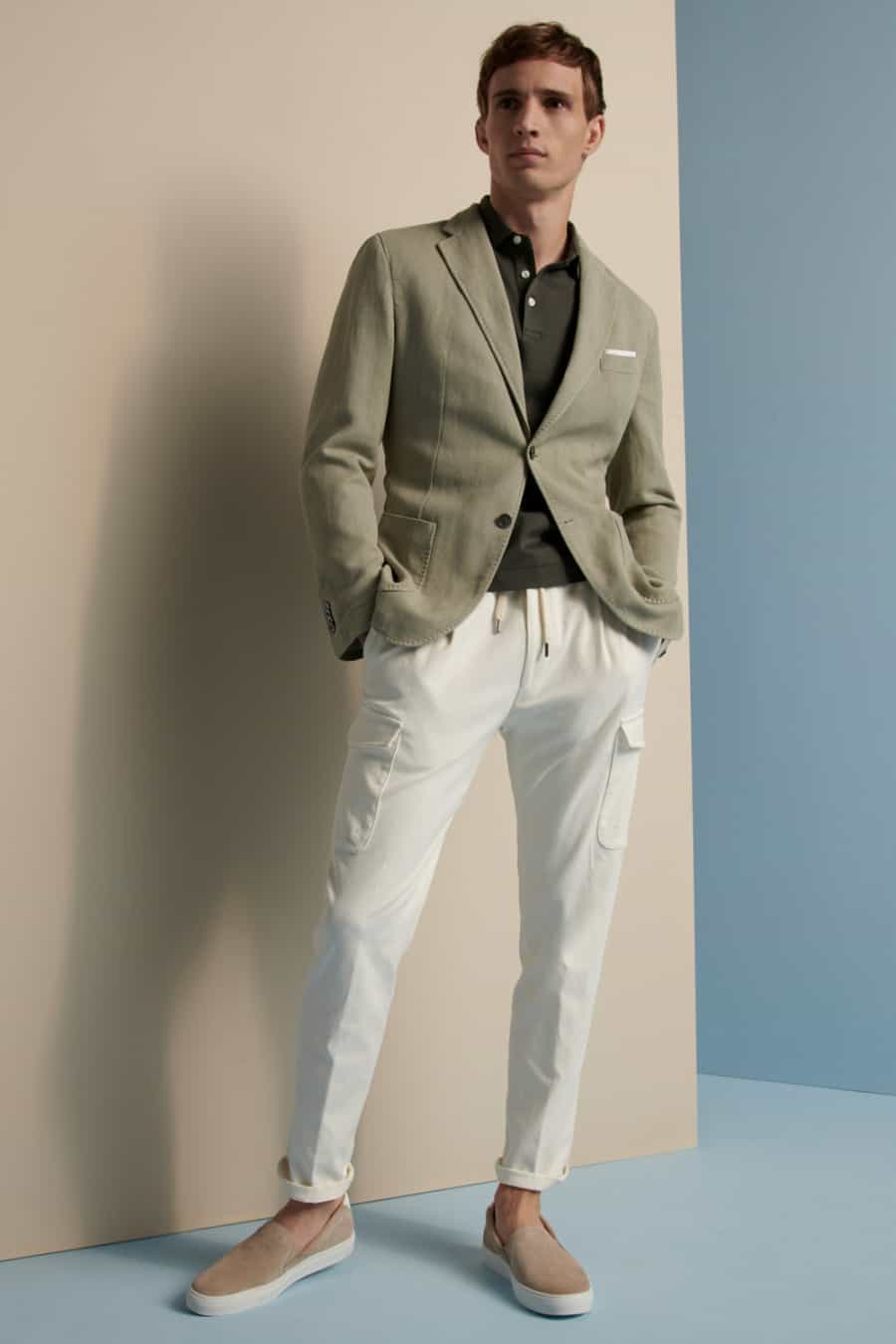 Men's white cargo pants, dark green polo shirt, light green blazer and suede loafers outfit